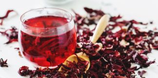 uma xícara de chá de hibisco com plantas de hibisco ao lado