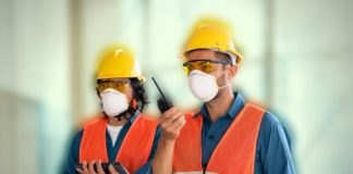 trabalhadores usando EPI como capacetes, coletes e mascaras para evitar doenças ocupacionais